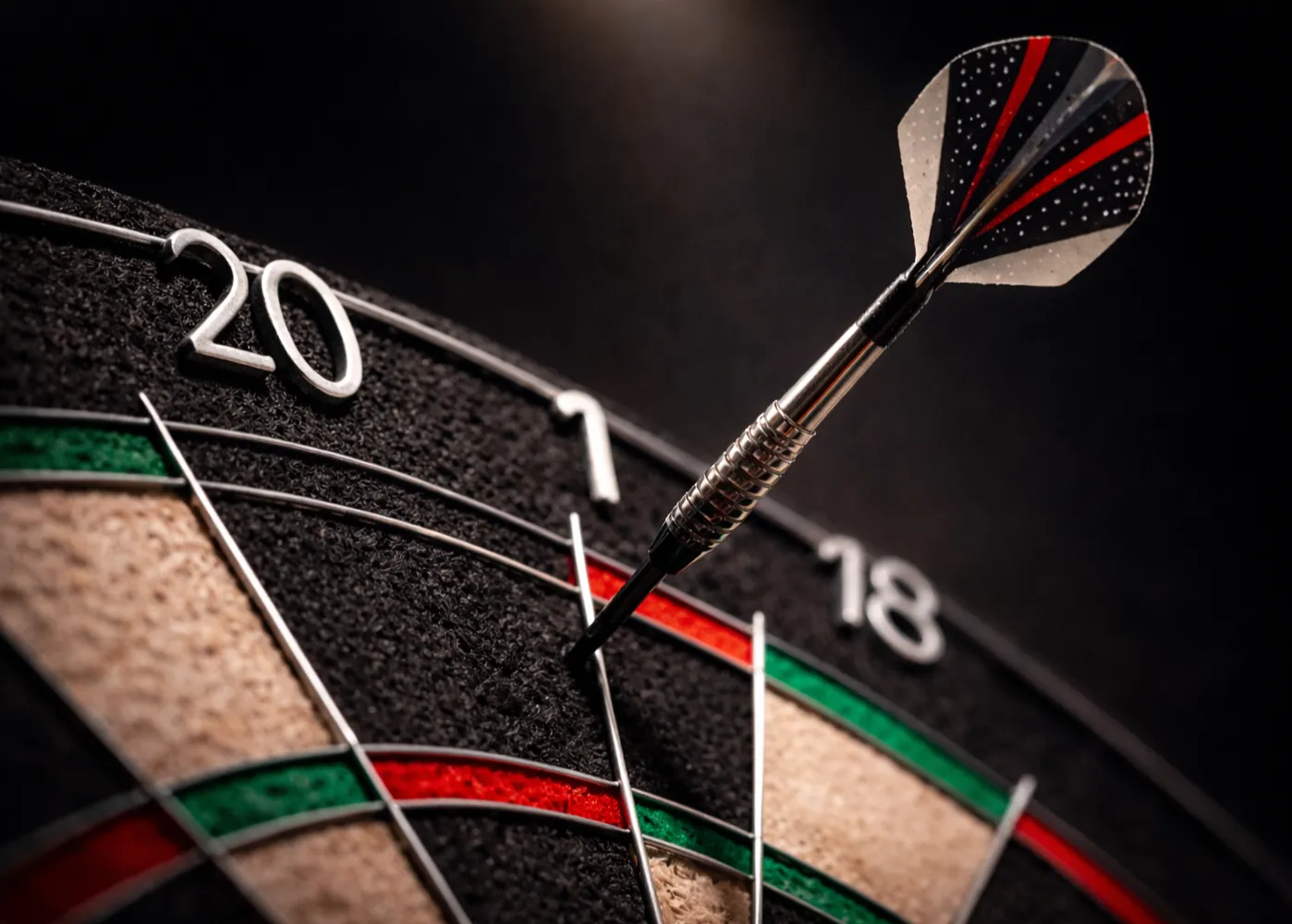 Nahaufnahme eines Dartpfeils auf der Doppel-20 einer professionellen Dartscheibe unter Bühnenbeleuchtung